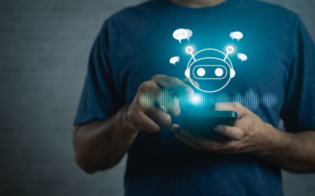 Okostelefont használó férfi felett megjelenő digitális mesterséges intelligencia chatbot ikon.