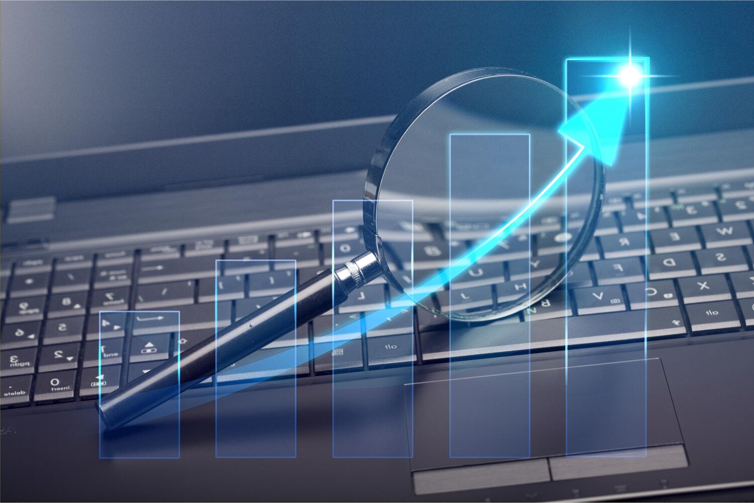 Laptop billentyűzetén fekvő nagyító és emelkedő kék grafikon, amely a keresőoptimalizálás növekedését jelképezi.